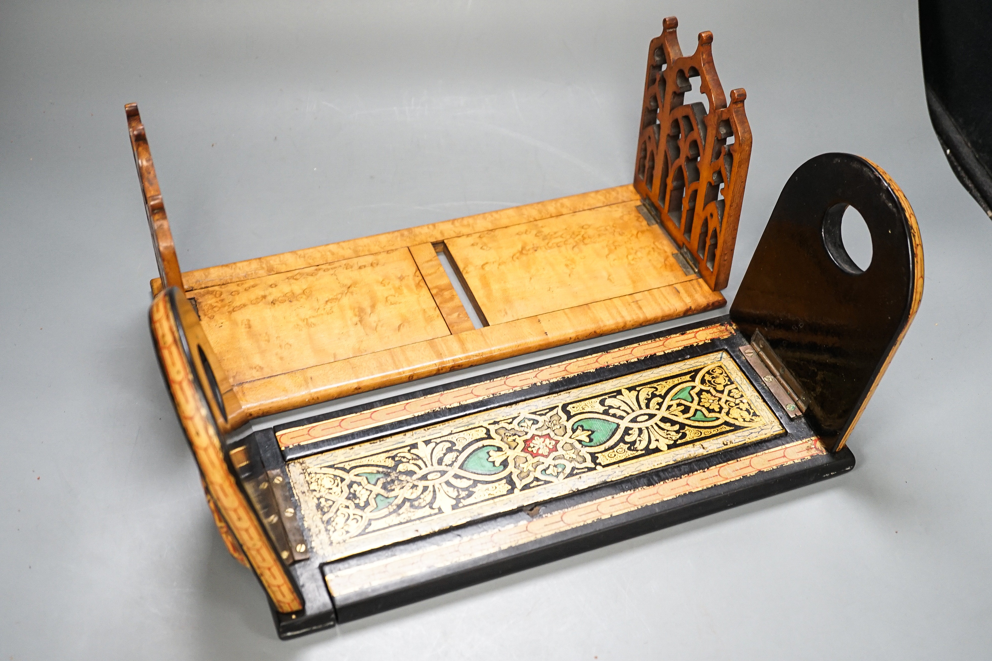 A Victorian Pugin style Gothic revival bird’s eye maple bookslide together with a japanned papier-mâché example (2), largest 34cms wide.